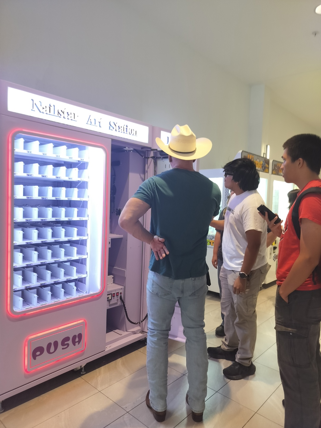 Three members of our team standing beside an open Nailstar machine during installation.